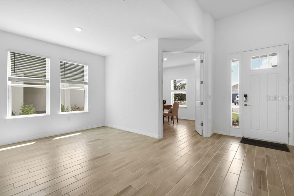A bright room with light wood-look tile flooring, white walls, and an open doorway — 5780 BINNACLE LANE, COCOA, FL
