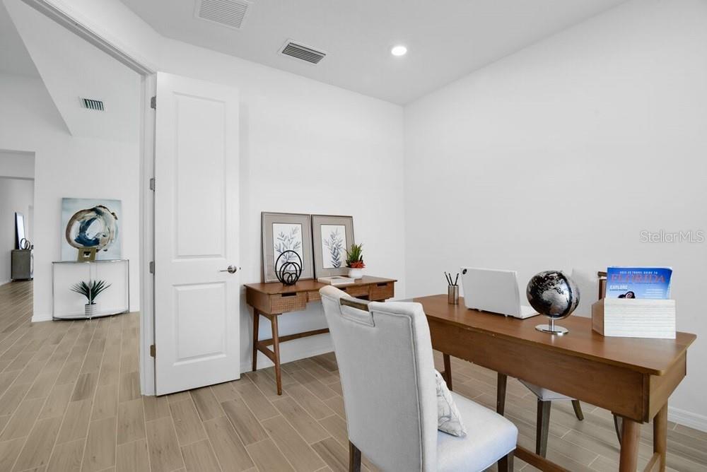 A home office features a wooden desk, a white chair, and light-colored tile flooring — 5780 BINNACLE LANE, COCOA, FL