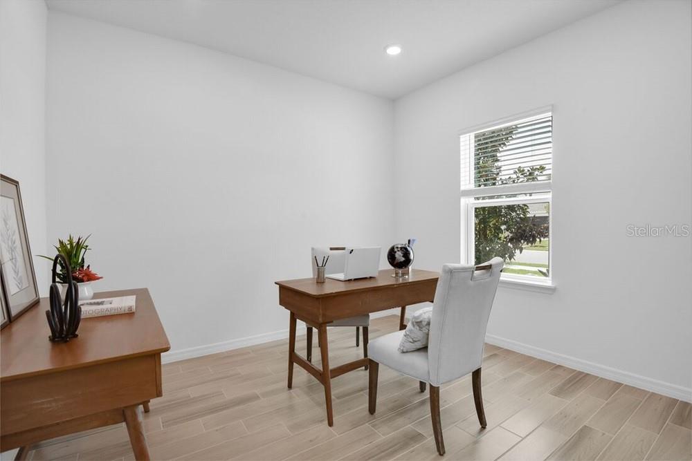 A home office with light wood-look flooring, white walls, and a window — 5780 BINNACLE LANE, COCOA, FL