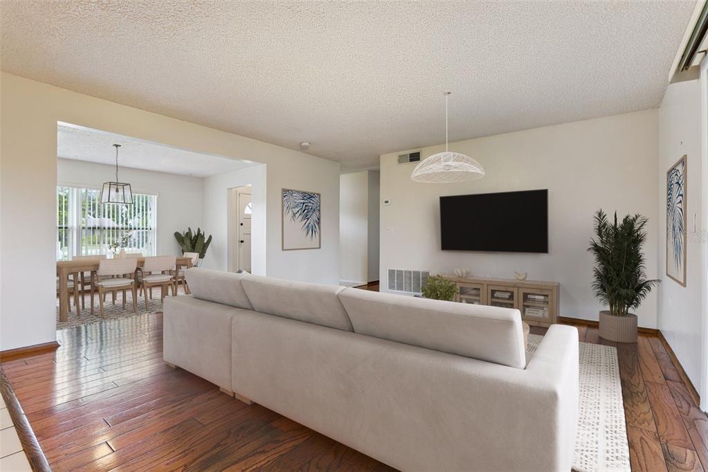 An empty living room features hardwood floors, a ceiling fan, and white walls — 4101 PLAYA COURT, BELLE ISLE, FL
