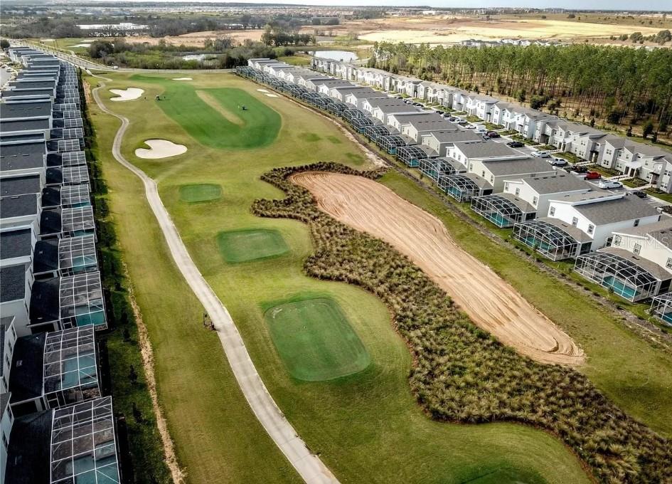 An aerial view shows a golf course fairway bordered by residential townhomes with screened-in pools — 8888 CABOT CLIFFS DRIVE, DAVENPORT, FL