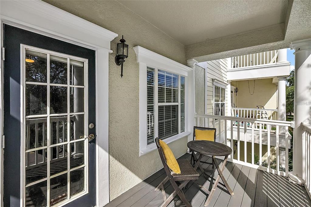 A covered balcony features a dark door, a window, and a small table with two chairs — 412 BLUE BAYOU LANE, WINTER SPRINGS, FL