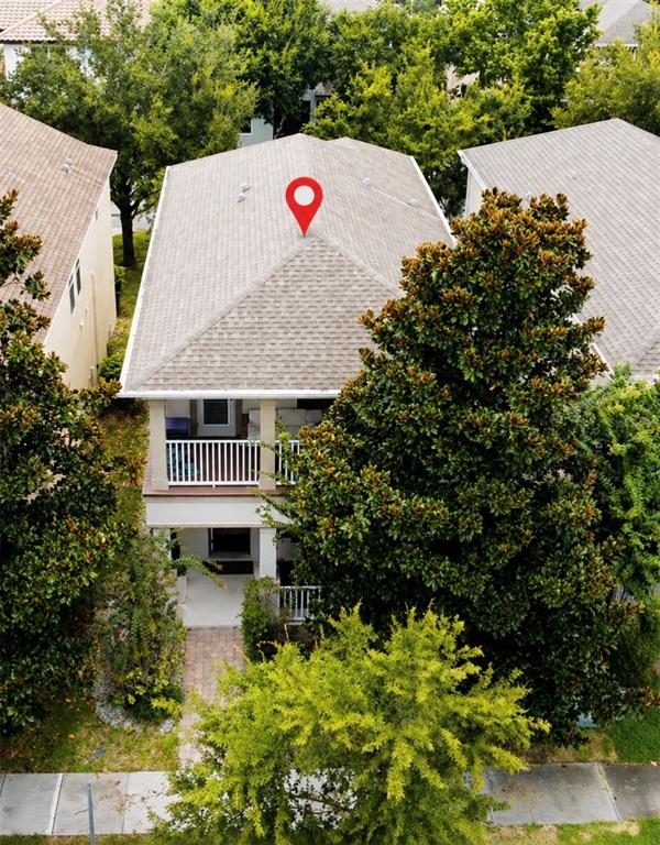 An aerial view of a two-story house with a shingled roof and a front balcony — 8630 POWDER RIDGE TRAIL, WINDERMERE, FL