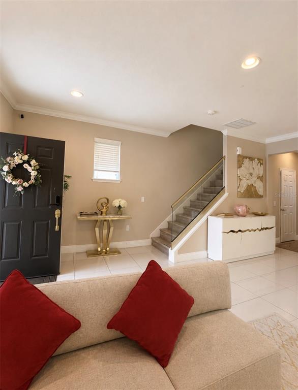 An entryway features a dark front door, a staircase with glass railings, and tile flooring — 8630 POWDER RIDGE TRAIL, WINDERMERE, FL
