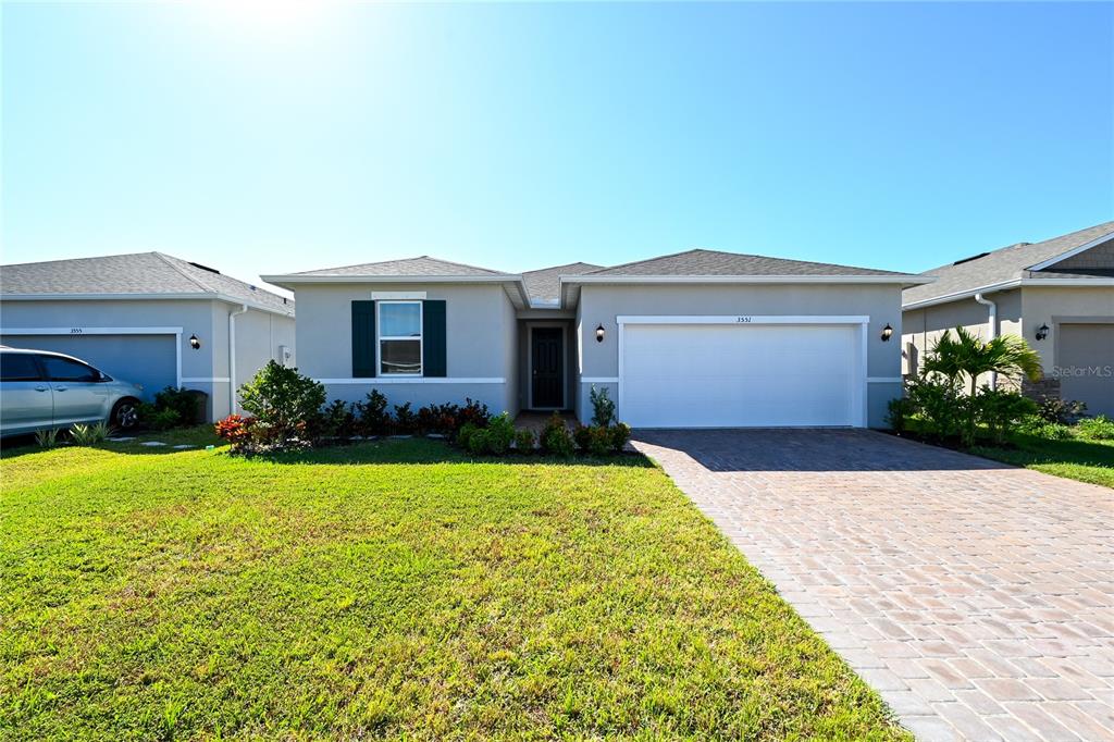 A single-story house with a white garage, gray exterior, and a paved driveway — 3551 74TH AVENUE CIRCLE E, SARASOTA, FL