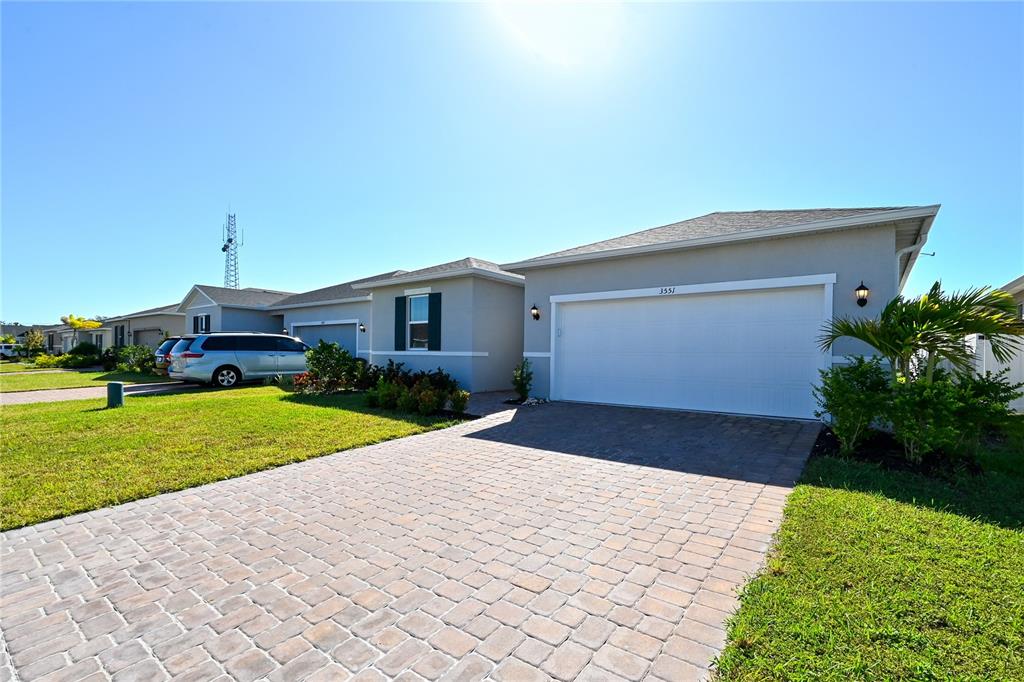 A single-story house with a paved driveway, two-car garage, and a light-colored stucco exterior — 3551 74TH AVENUE CIRCLE E, SARASOTA, FL