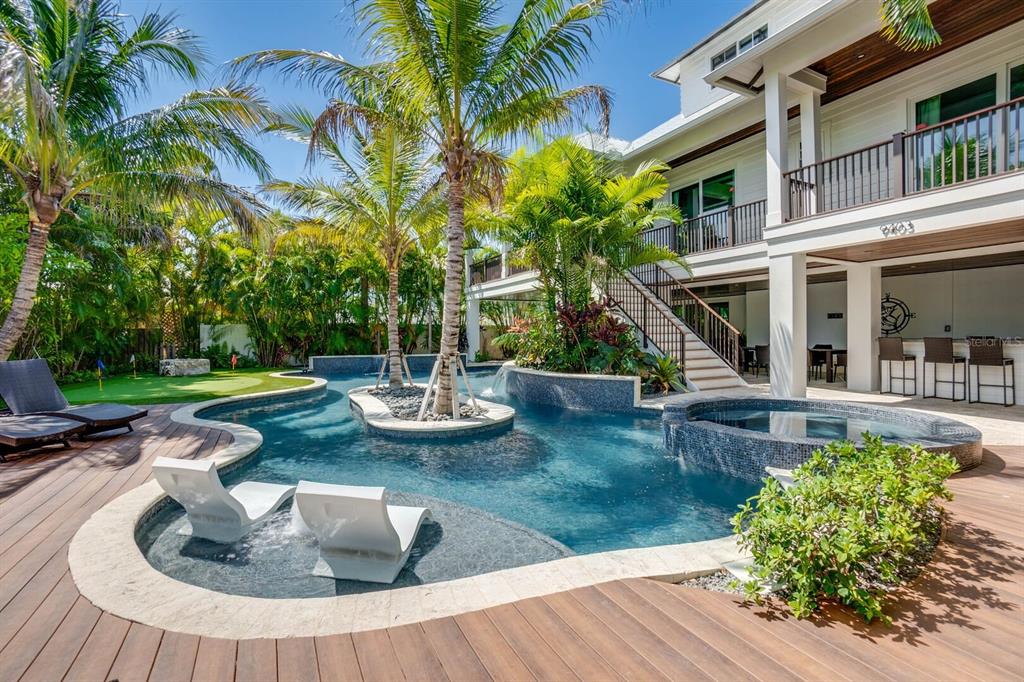 A multi-level home features a swimming pool with a central island and a sun shelf — 9403 GULF DR, ANNA MARIA, FL