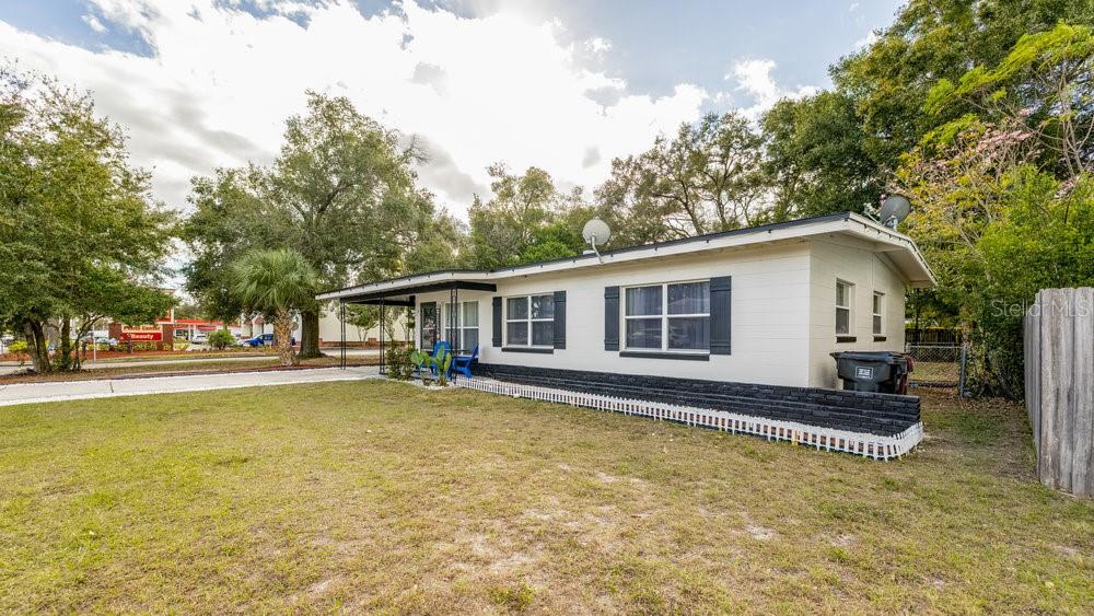 A single-story house with white siding, a dark brick base, and a covered front porch — 1406 CONWAY ROAD, ORLANDO, FL