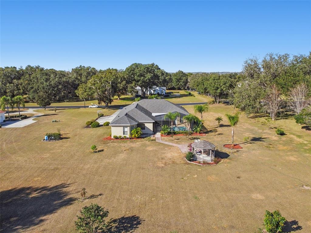 An aerial view shows a single-story house with a pool and gazebo on a large lot — 14308 WILLOW RUN, DADE CITY, FL