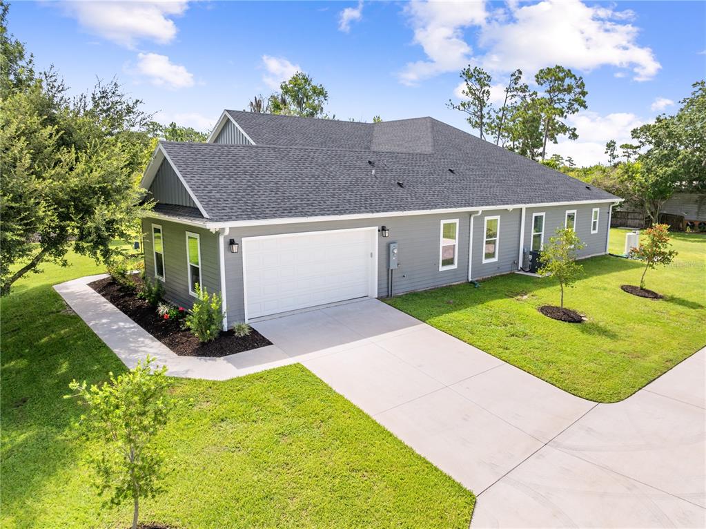 An aerial view of a gray house with a two-car garage and a concrete driveway — 4024 SYLVESTER DRIVE, ST CLOUD, FL