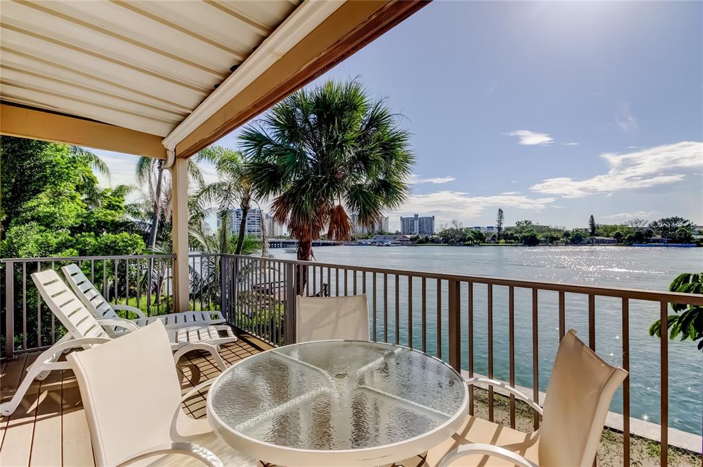 A living room with light gray sofas, a ceiling fan, and an open dining area — 135 92ND AVENUE UNIT 5, TREASURE ISLAND, FL