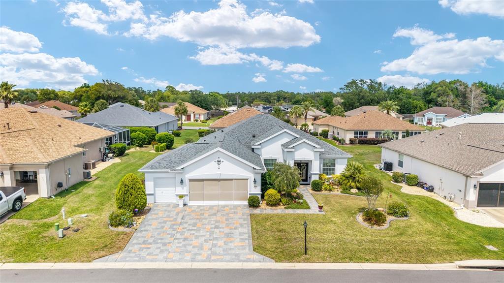 An aerial view of a single-story suburban house with a paved driveway and gray roof — 9290 SE 120TH LOOP, SUMMERFIELD, FL