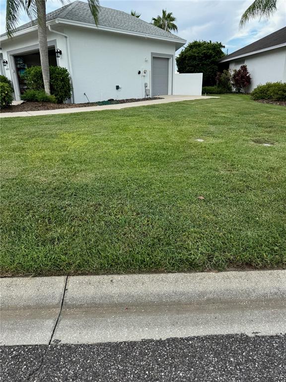 A view of a residential lawn and the exterior of a house with a garage — 6623 BENDELOW DRIVE, LAKELAND, FL