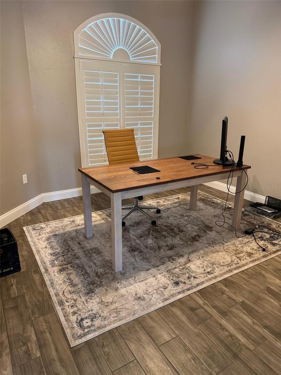 A home office features a wooden desk, a mustard-colored chair, and a patterned area rug — 6623 BENDELOW DRIVE, LAKELAND, FL