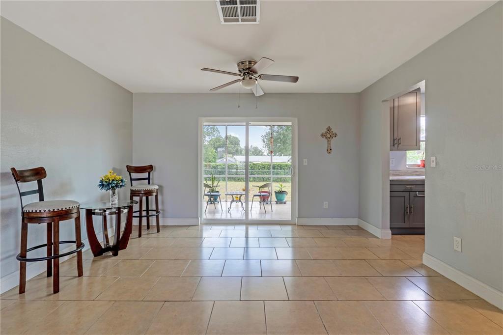A dining area features tile flooring, a ceiling fan, and sliding glass doors to a patio — 2633 BEAL STREET, DELTONA, FL