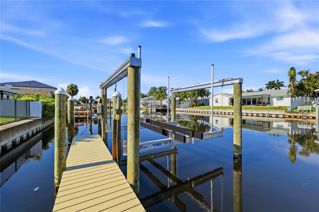 An aerial view shows three waterfront houses with docks along a canal in a neighborhood — 4152 13TH LANE NE, ST PETERSBURG, FL