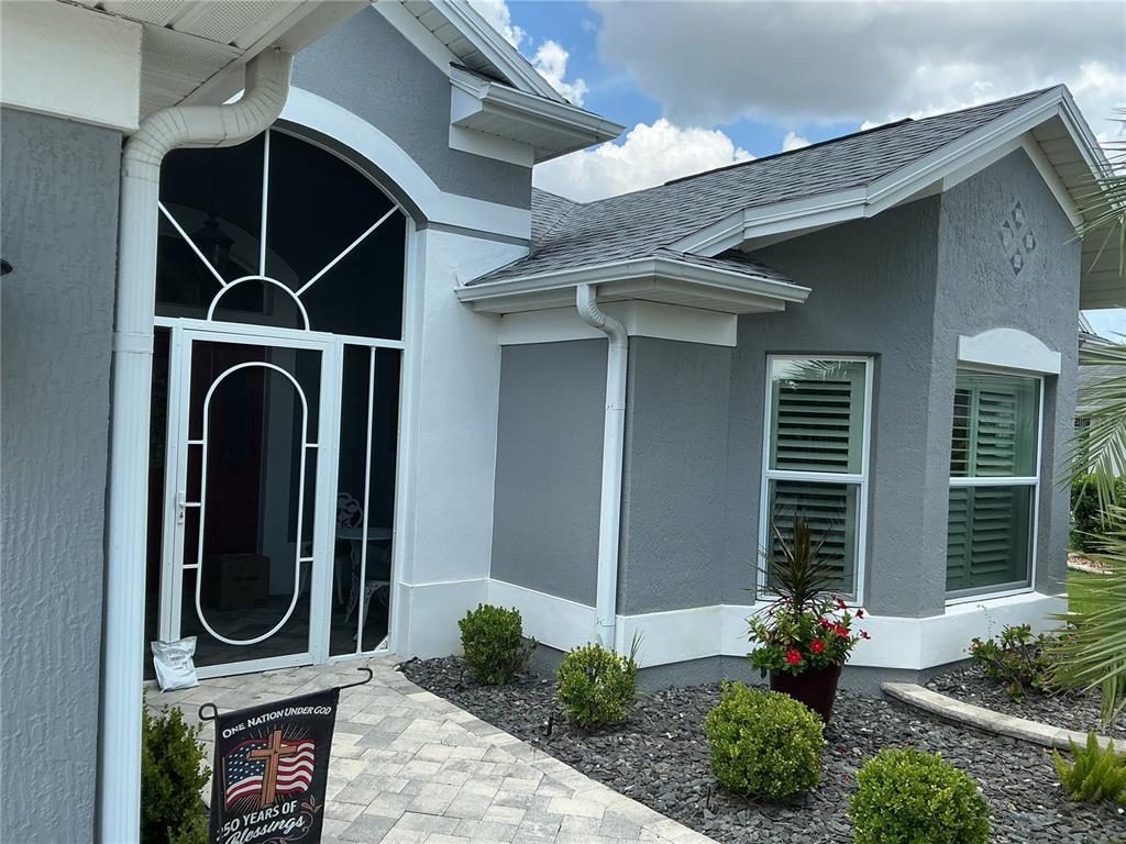 The exterior of a house features a white screen door with a decorative archway — 2841 APACHE COURT, THE VILLAGES, FL