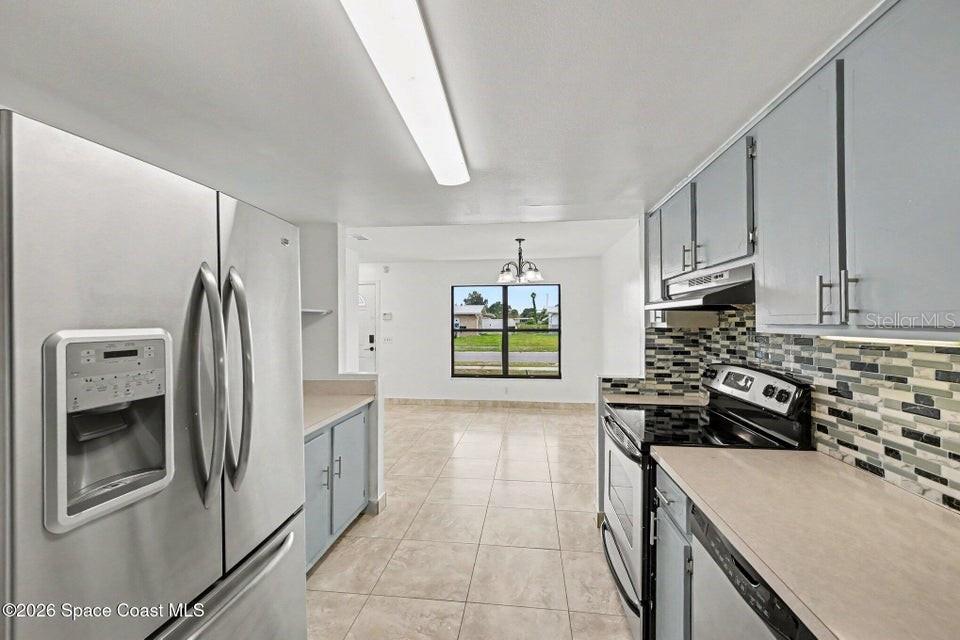 A kitchen with stainless steel appliances, light gray cabinets, and a tiled backsplash — 2292 LAKEVIEW DRIVE, MELBOURNE, FL