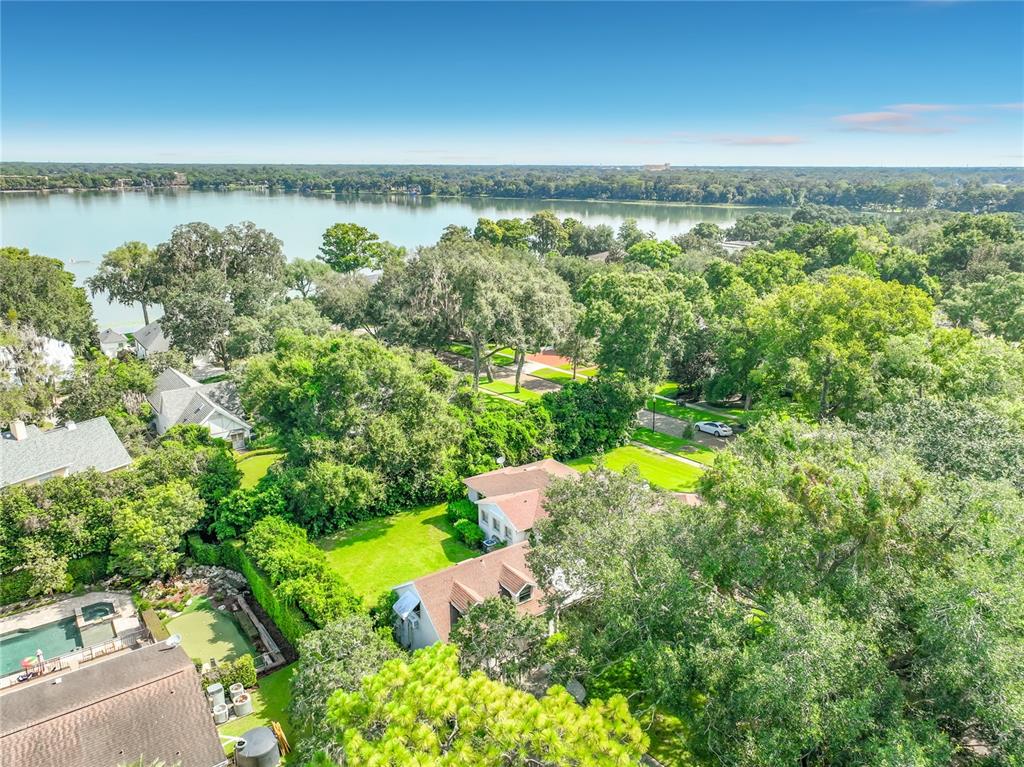 An aerial view shows a house with a brown roof surrounded by trees and grass — 1661 LAUREL ROAD, WINTER PARK, FL