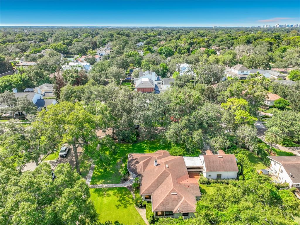 An aerial view of a suburban house with a brown roof surrounded by dense trees — 1661 LAUREL ROAD, WINTER PARK, FL