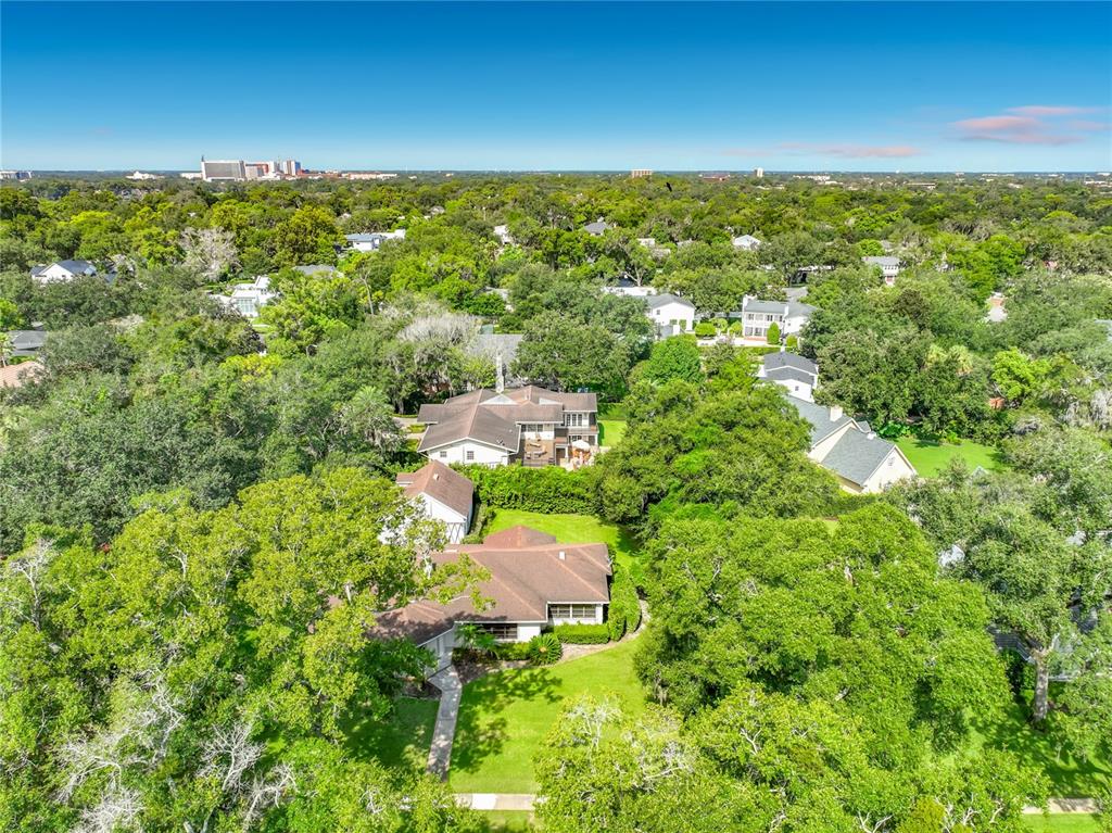 An aerial view of a suburban neighborhood featuring houses surrounded by dense green trees — 1661 LAUREL ROAD, WINTER PARK, FL