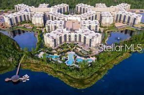 Aerial view of a large multi-story apartment complex with a pool and surrounding lake — 14501 GROVE RESORT AVE UNIT 1535, WINTER GARDEN, FL