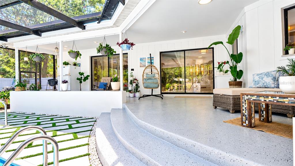 A white kitchen features a coffee station, stainless steel refrigerator, and marble-topped island — 1307 NORMANDY CIRCLE, PALM HARBOR, FL