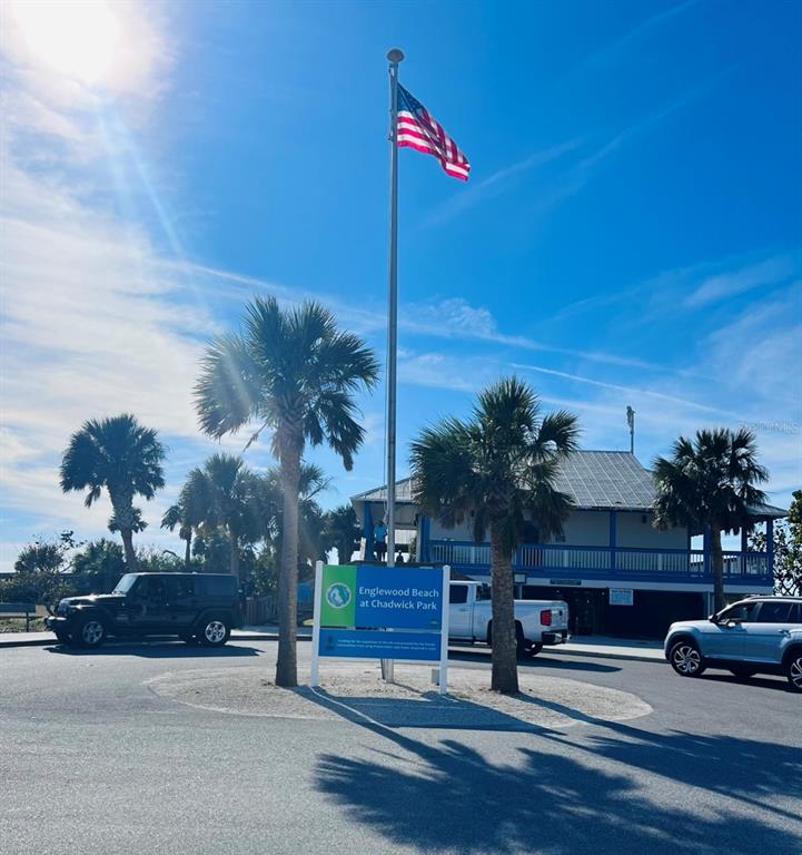 A sign for Englewood Beach at Chadwick Park stands in front of a two-story building — OLEANDER DRIVE, NORTH PORT, FL
