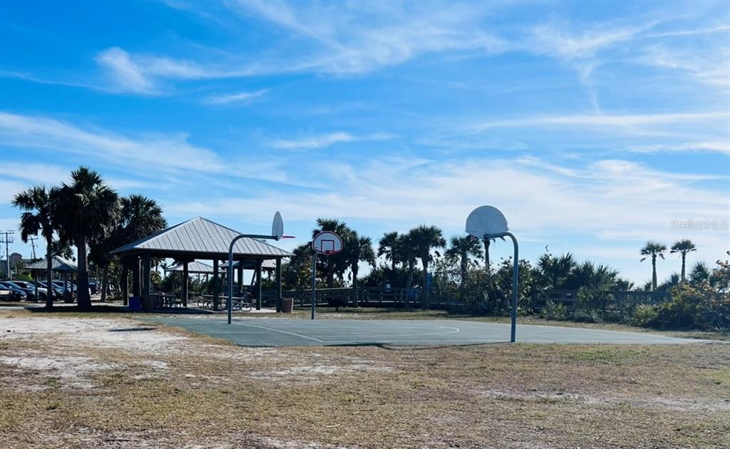 An outdoor basketball court sits near a covered pavilion surrounded by palm trees — OLEANDER DRIVE, NORTH PORT, FL