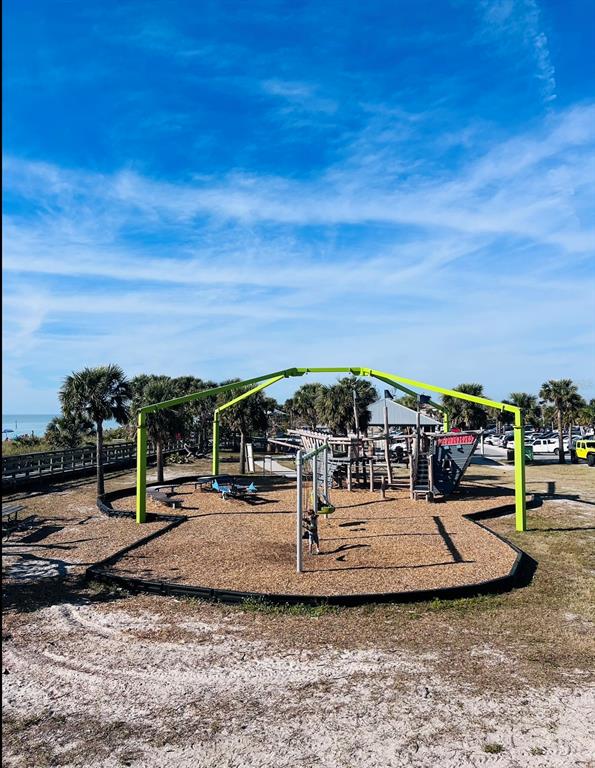 An outdoor playground with a large green metal frame structure and wood chip ground cover — OLEANDER DRIVE, NORTH PORT, FL