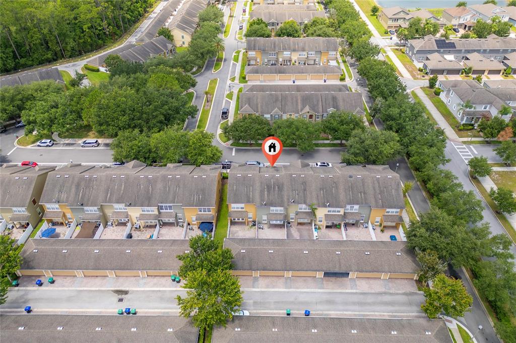 An aerial view shows a row of townhouses with attached garages and a red location pin — 7723 FAIRGROVE AVENUE, WINDERMERE, FL