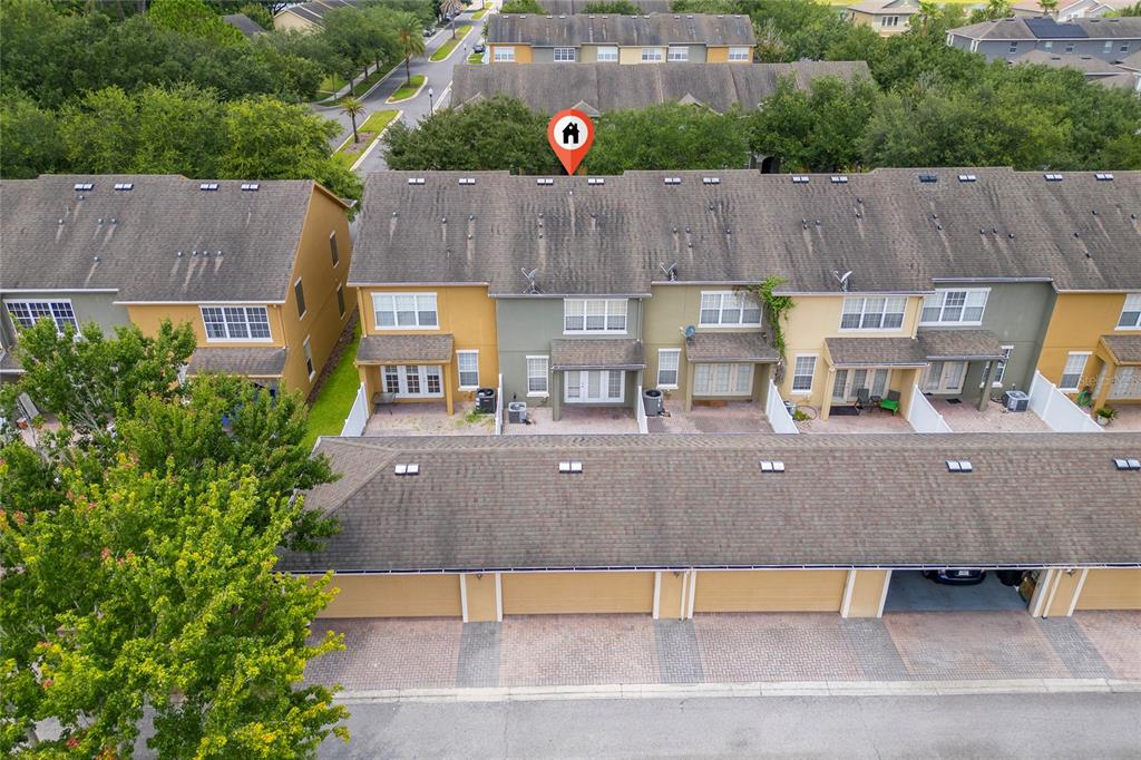 An aerial view shows a row of townhomes with attached garages and a parking area — 7723 FAIRGROVE AVENUE, WINDERMERE, FL