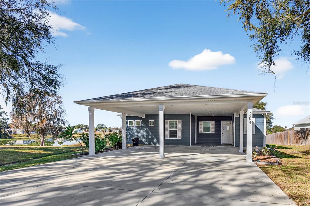 A single-story house with dark blue siding and a large concrete carport — 260 S CENTRAL AVENUE, UMATILLA, FL