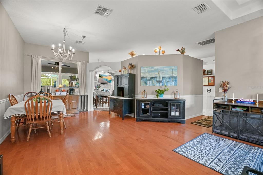 A dining area with hardwood floors, a chandelier, and a central wall with artwork — 2117 LARKSPUR COURT, TRINITY, FL