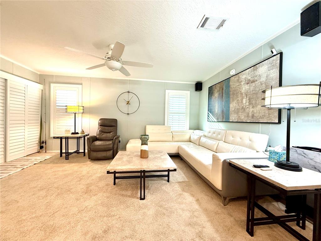 A living room features a white sectional sofa, a coffee table, and a recliner — 124 E SAINT ANNES CIRCLE, APOLLO BEACH, FL