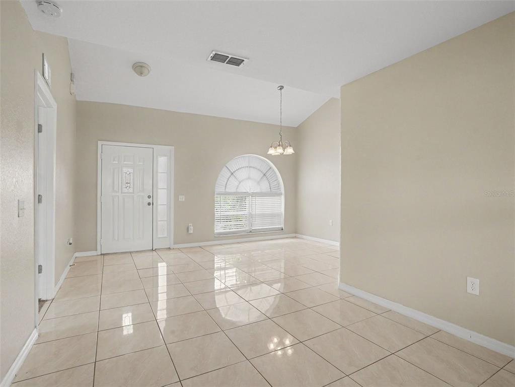 A kitchen features dark blue cabinets, granite countertops, stainless steel appliances, and tile flooring — 1802 HUDSON COURT, KISSIMMEE, FL