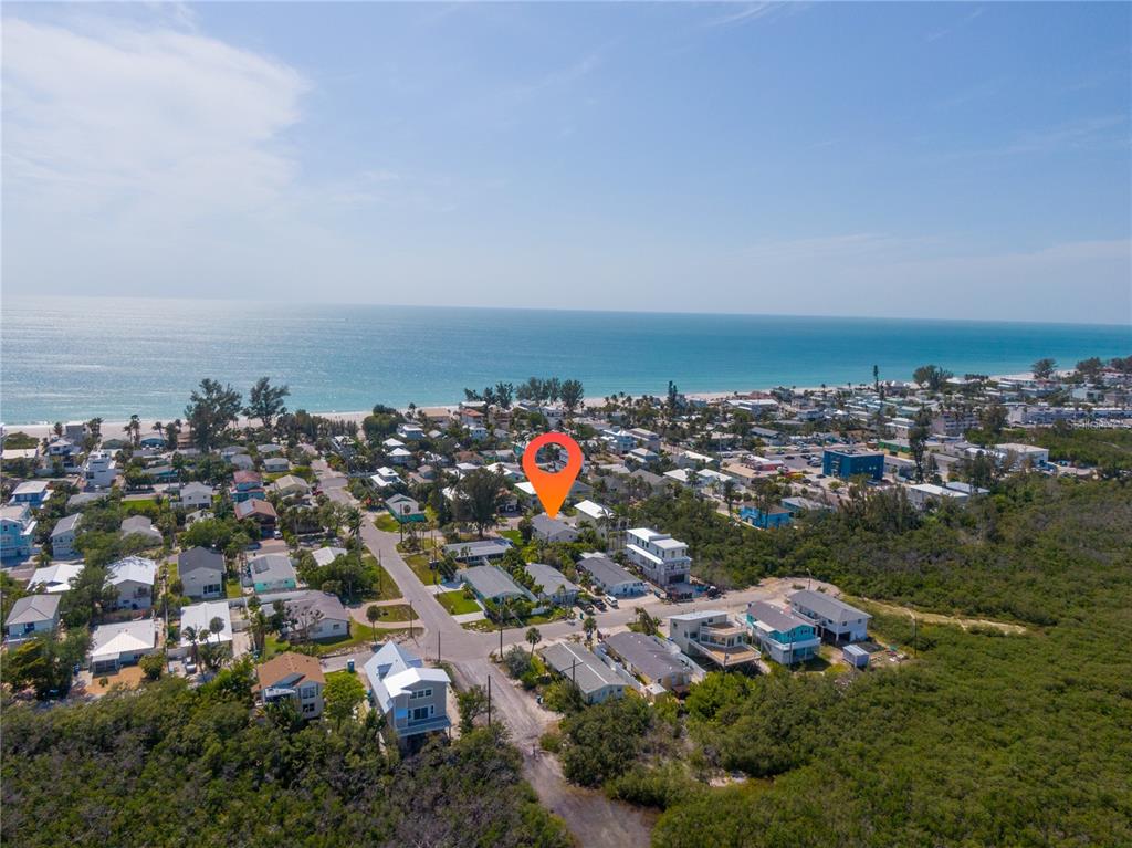 An aerial view shows a coastal neighborhood with a marked house near the beach — 2905 AVENUE C, HOLMES BEACH, FL