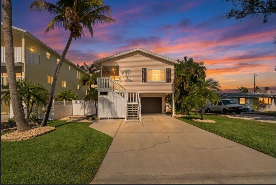 An elevated house with a concrete driveway, a garage, and a staircase leading to the entrance — 2905 AVENUE C, HOLMES BEACH, FL