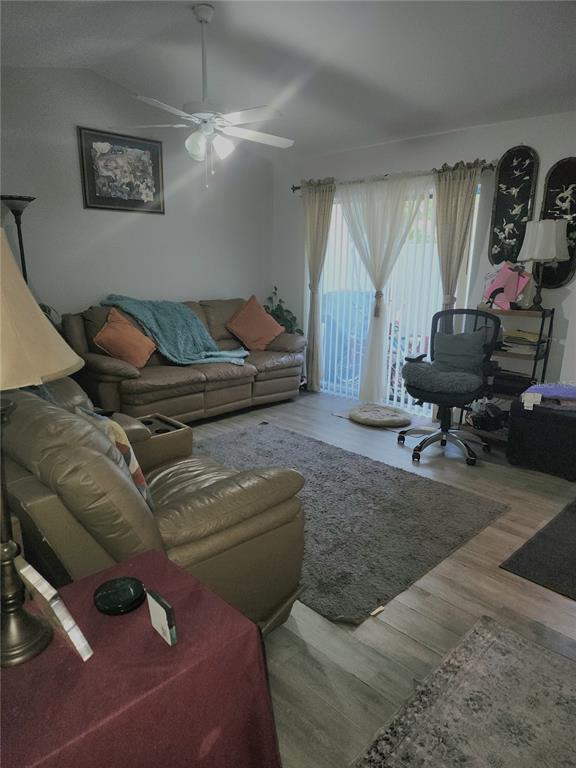A living room features a brown leather sofa, a matching recliner, and sliding glass doors — 4154 16TH STREET E UNIT 15, ELLENTON, FL