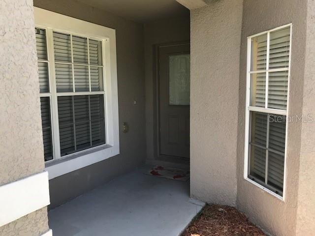 A single-story house with a two-car garage and a concrete driveway under a cloudy sky — 3078 VERBENA DRIVE, DELTONA, FL