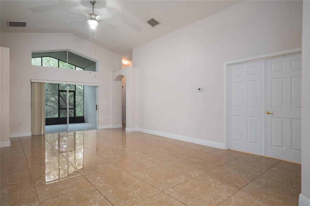 A kitchen features dark wood cabinets, stainless steel appliances, granite countertops, and light-colored tile flooring — 3078 VERBENA DRIVE, DELTONA, FL