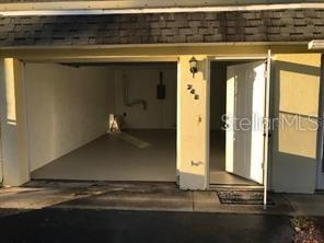 An open garage with a concrete floor and an adjacent white entry door — 248 TIMBERLINE TRAIL, ORMOND BEACH, FL