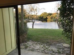 A view from a doorway looking out at a grassy yard and a pond — 248 TIMBERLINE TRAIL, ORMOND BEACH, FL