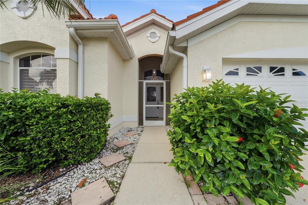 A concrete walkway leads to the front entrance of a house with a garage — 6817 SUPERIOR STREET CIRCLE, SARASOTA, FL