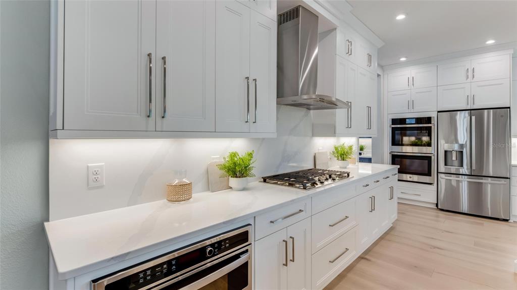A modern kitchen features white cabinets, stainless steel appliances, and a marble-style backsplash — 1246 CRESSWIND BOULEVARD, DELAND, FL
