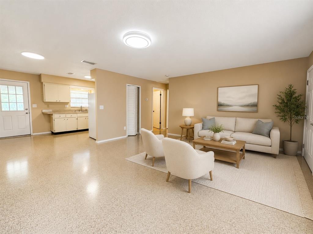 An open-concept living room with beige walls, light-colored furniture, and speckled flooring — 5222 BOGDONOFF DRIVE, SEFFNER, FL