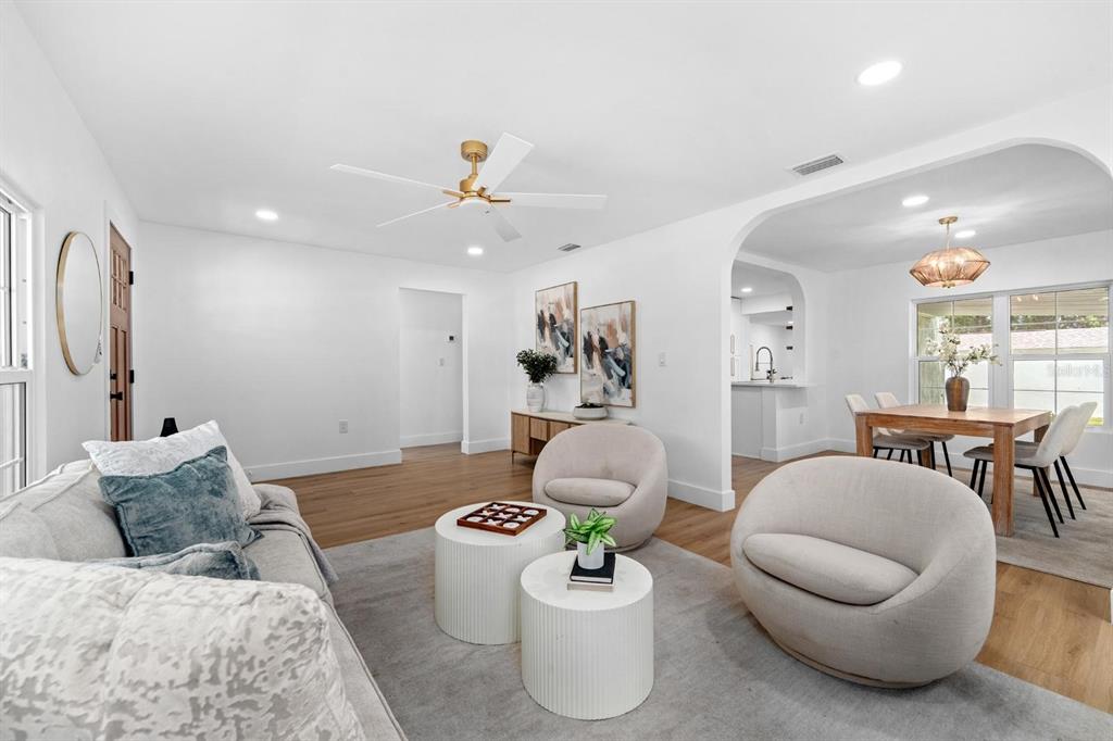 A bright living room features white walls, wood floors, a gray area rug, and modern furniture — 1230 E HENRY AVENUE, TAMPA, FL