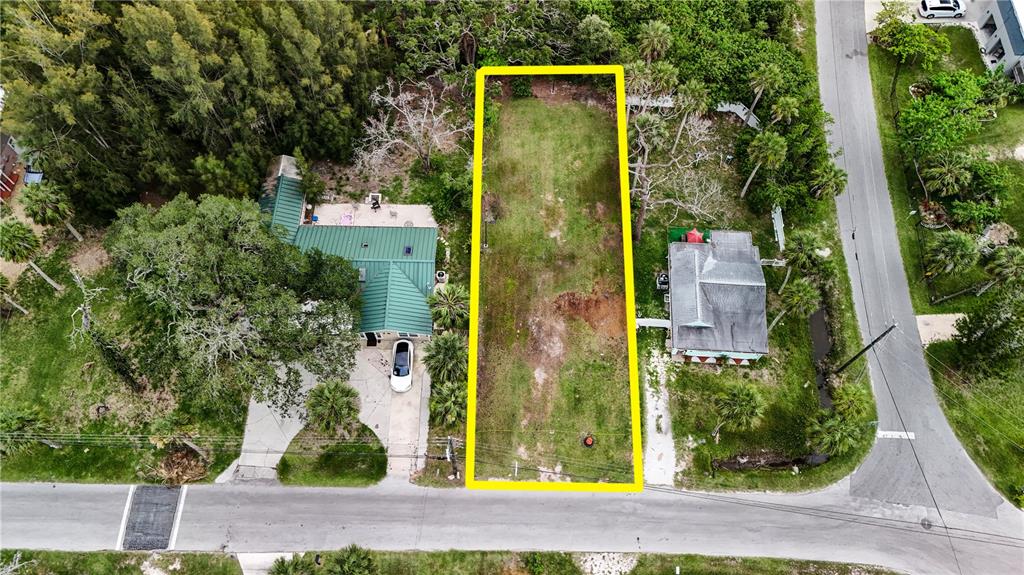 An aerial view shows a vacant rectangular lot outlined in yellow between two houses — 4846 LIMESTONE DRIVE, PORT RICHEY, FL