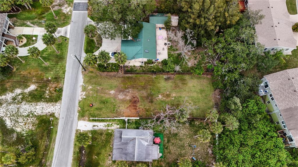 An aerial view shows a vacant residential lot situated between two houses and a road — 4846 LIMESTONE DRIVE, PORT RICHEY, FL