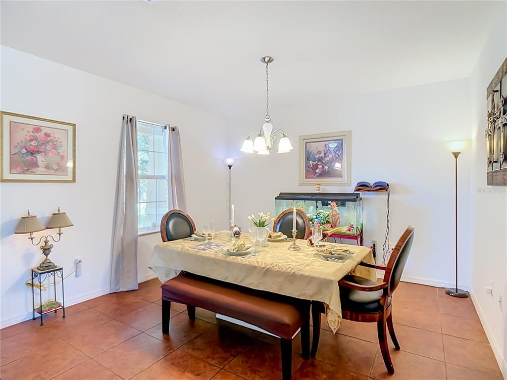A dining room features a table with a bench and chairs, tile flooring, and an aquarium — 205 TIFTON STREET, WINTER HAVEN, FL